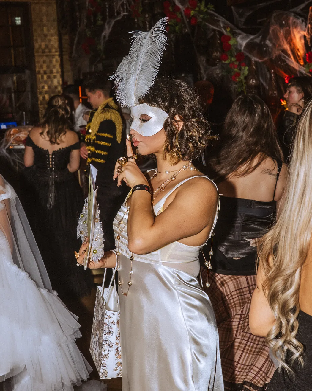 Gästin mit Federmaske und Geschenktüte